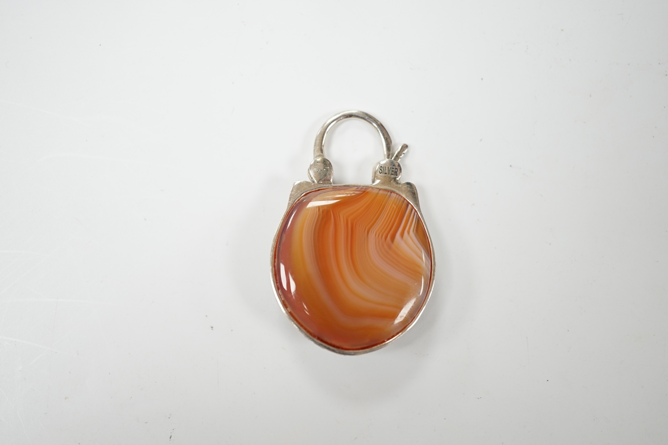 A white metal (stamped silver) and banded agate set padlock pendant, modelled as an owl, 39mm. Condition - good